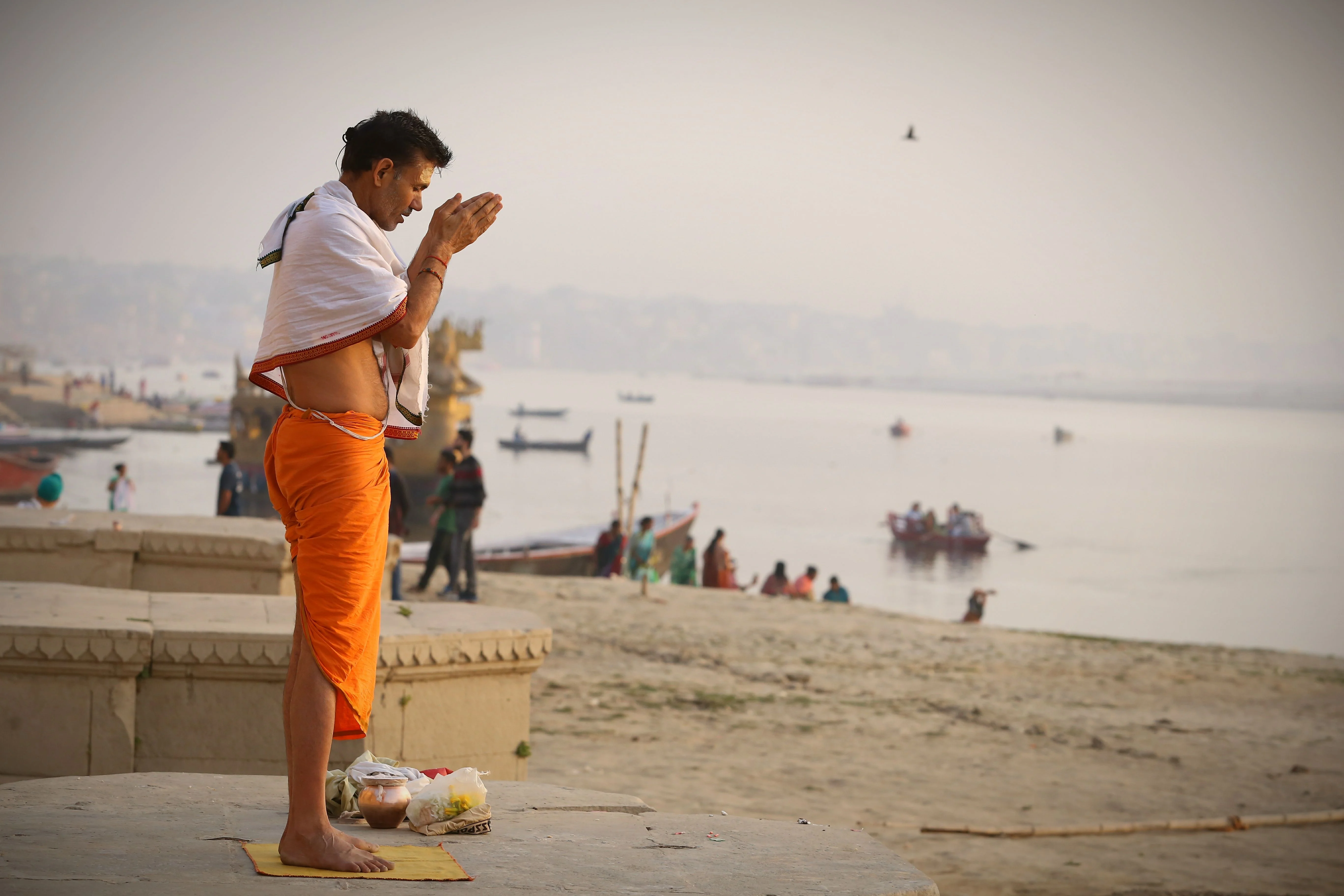 A man performs morning prayer on the ghats of Varanasi, overlooking the Ganga